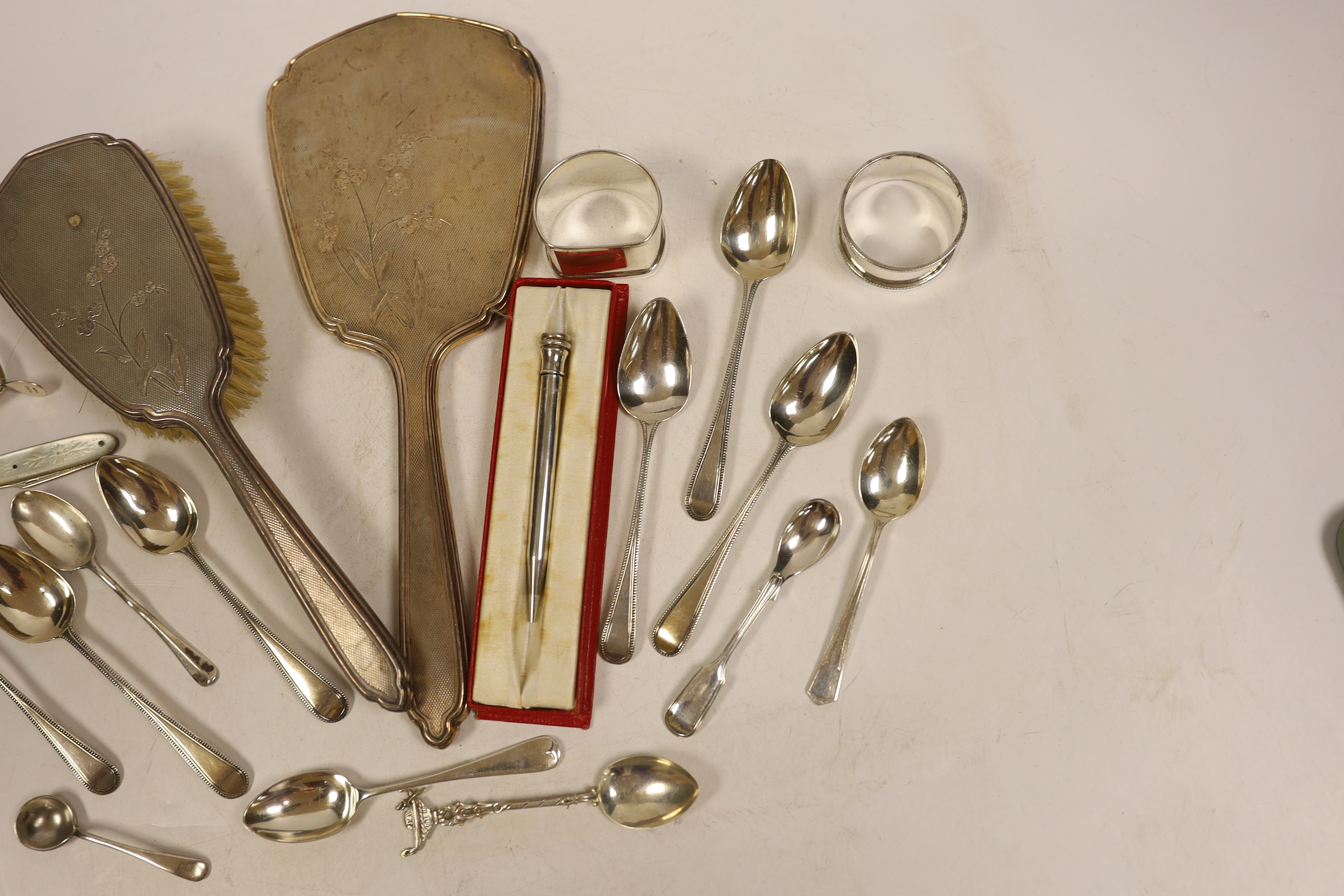 A silver mounted hand mirror and hair brush and sundry small silver including teaspoons, Georgian travelling fork, wishbone sugar nips, napkin rings and pencil.